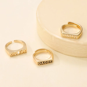 Three gold adjustable rings with rectangular plates featuring Melika, Daddy, and Momy engravings