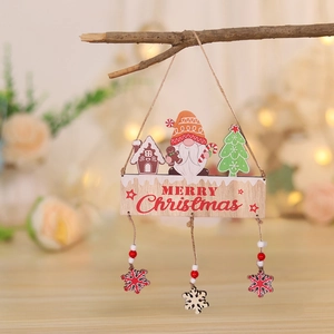 Detail of wooden gnome and gingerbread house Merry Christmas hanging ornament on branch