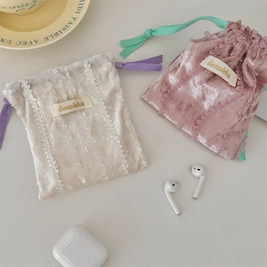 Detailed view of lace drawstring velvet pouches for storing wireless earphones and jewelry