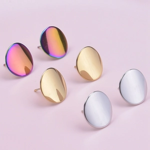 Macro detail of three pairs of oval stud earrings in rainbow, gold, and silver finishes