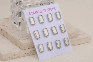 Macro view of twelve rectangular silver stainless steel stud earring sets on display