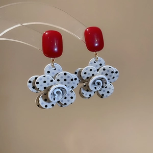 Detail view of resin floral drop earrings with red square top and polka dot petals
