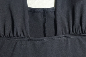Close-up of the professional flatlock stitching and premium black fabric texture
