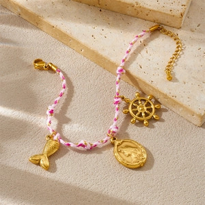Bracelet tressé rose avec breloques dorées en queue de sirène et gouvernail de bateau
