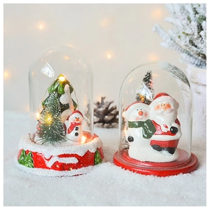 Detail of Santa Claus and snowman in lit glass dome with warm LED Christmas lights