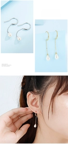 Detailed close-up of long teardrop pearl earrings with gold and silver hooks