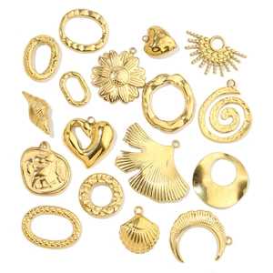 Flat lay of assorted gold-plated stainless steel charms in heart, shell and leaf shapes
