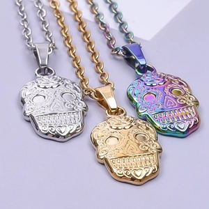 Detailed view of Mexican skull pendants in silver, gold, and rainbow stainless steel