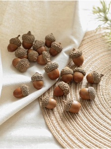 Close-up of natural brown acorns on linen fabric for rustic Christmas decoration