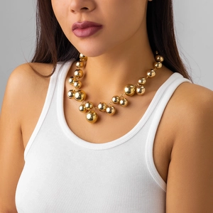 Close-up of punk style golden beaded necklace with high-shine polished metallic finish