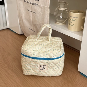 Close-up of quilted cotton cosmetic bag with colorful polka dots and blue zipper