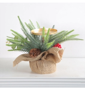 Detail of pine cone, red berries, and gold metal candle holder on burlap base