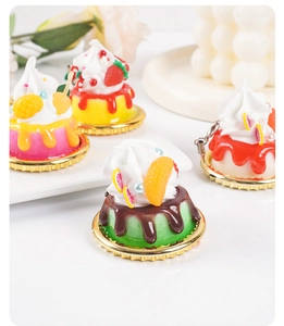 Close-up of artificial fruit cream cakes with strawberry and orange on golden trays