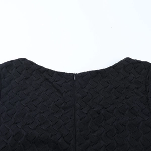 Detalle de vestido de encaje negro con escote de malla y cremallera invisible en espalda