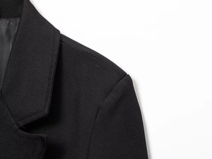 Detailed view of the fine twill fabric and shoulder stitching on this black blazer coat