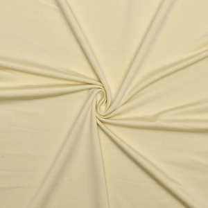 Gros plan du tissu beige de la robe dos nu montrant la texture lisse et plis