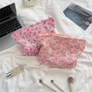 Detail of pink floral quilted makeup bags with zipper closure in a cozy lifestyle setting