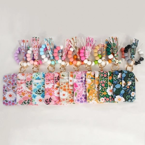 Flat lay of colorful floral silicone bead wristlet keychain sets with card holder wallets