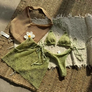 Detailed flat lay of a grass green crochet 3-piece bikini set with sheer mesh skirt