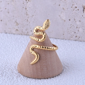 Detailed view of adjustable golden snake ring with scales on a wooden display
