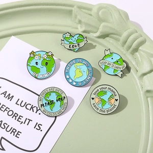 Set of 6 Earth Day enamel pins with eco-friendly slogans on a green decorative tray