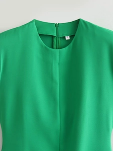 Détail du col d'une robe sans manches vert vif avec étiquette taille S sur tissu fluide
