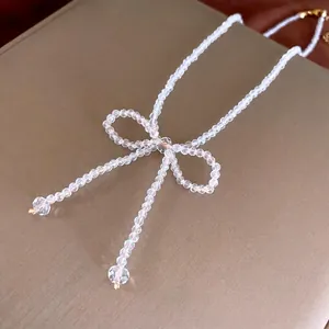 Elegant beaded crystal necklace featuring a large bow pendant and polished multifaceted beads