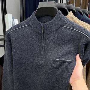 Detail of dark grey knit sweater showing half-zip stand collar and shoulder stripe accents
