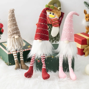 Three plush Christmas gnomes in brown red and pink sitting on festive gift boxes decoration