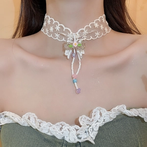 Detailed close-up of white lace choker necklace with bow, floral beads and soft tassels