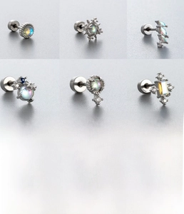 Macro detail of silver titanium steel cartilage studs with iridescent moonstone inlay