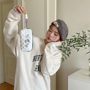 Detail of white quilted stationery bag with cute floral embroidery and purple lanyard