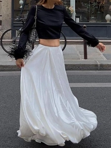 Chic two-piece set featuring black feather-cuff top and white satin A-line midi skirt