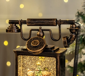 Detail of vintage bronze Christmas telephone lantern with snow globe scene and warm LED light