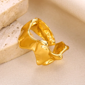 Macro detail of gold-plated liquid metal style irregular ring on a natural stone base