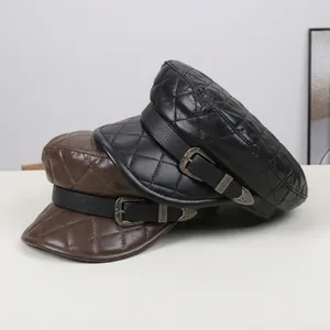 Close-up of quilted PU leather newsboy caps with decorative buckle straps in black and brown