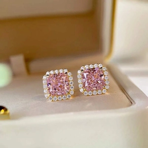 Macro view of pink square gemstone earrings with golden halo setting and tiny diamonds