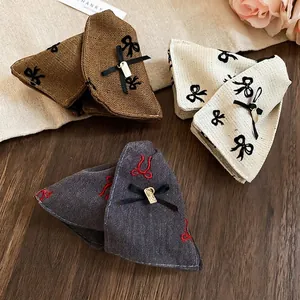 Three bow hair clips set featuring brown herringbone, cream woven, and grey denim fabrics