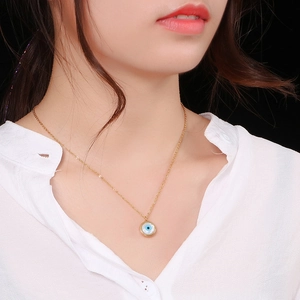 Golden Evil Eye teardrop pendant necklace on model with minimalist titanium steel chain