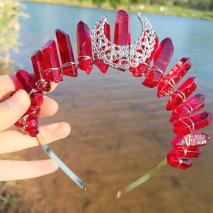 Detailed close-up of a handmade silver crescent moon crown with faceted red crystals