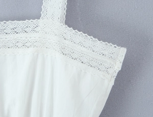 Close-up of the delicate white lace detailing on the neckline of the elegant top
