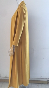 Detail view of ginger yellow knit cardigan showing ribbed texture and side pocket design