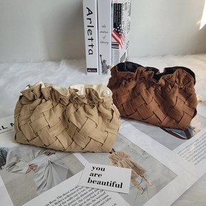Detail of woven texture corduroy bag with pearl accents and drawstring closure