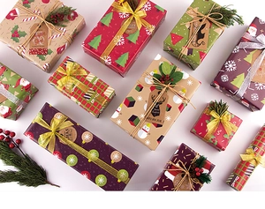 Flat lay of Christmas wrapping paper with reindeer and Santa motifs on gift boxes