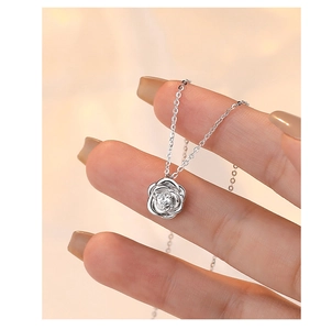 Macro shot of silver rose pendant necklace featuring a sparkling cubic zirconia center
