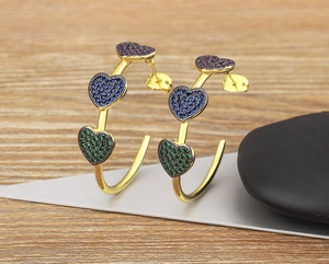 Detail of 18k gold plated C-hoop earrings featuring colorful heart-shaped zircons