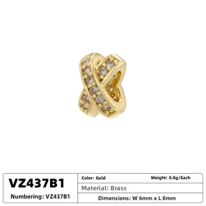 Detail of cross X-shaped brass gold plated bead with micro-set cubic zirconia stones