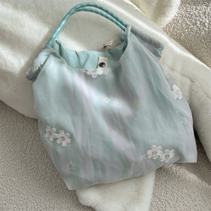 Detailed close-up of mint green tulle tote bag featuring 3D white floral embroidery