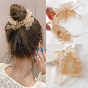 Detail of a large champagne mesh bow hair claw clip showing texture and secure grip design