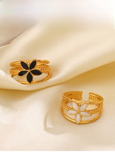 Detail of 18K gold plated three-layer rings with black and white floral enamel designs